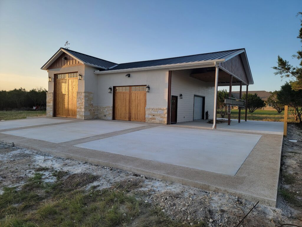 Stone-accented shop with large concrete drive aprons and parking pad