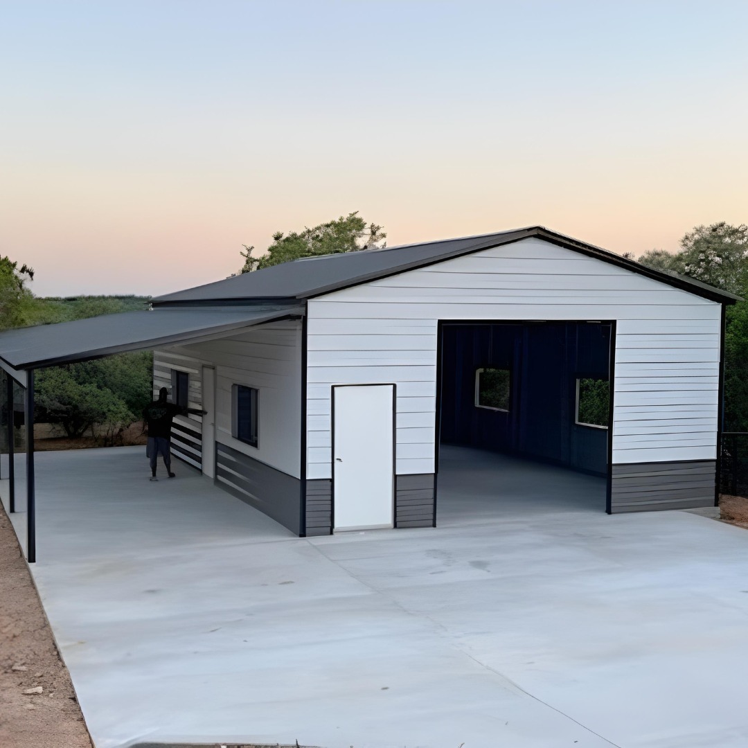 White metal shop with attached lean-to on a fresh concrete slab and apron